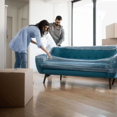 Contents insurance - Young couple unpacking a new modern sofa in their apartment